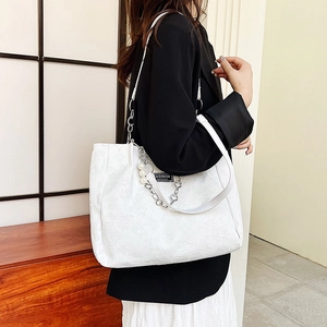 Sac fourre-tout en dentelle blanche avec breloques perles porté à l'épaule mode