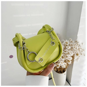 Détail du sac de selle vert néon avec chaîne métallique argentée et grand anneau décoratif