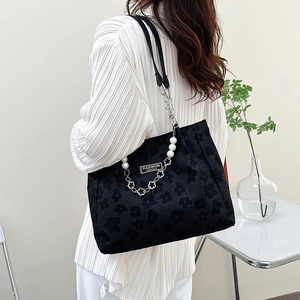 Grand sac cabas noir à fleurs en relief avec chaîne de perles porté à l'épaule