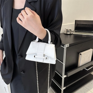 Chic white mini leather handbag with chain strap styled on a black blazer outfit