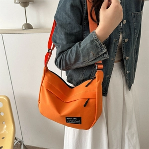 Fashionable vibrant orange crescent crossbody bag with adjustable wide fabric strap
