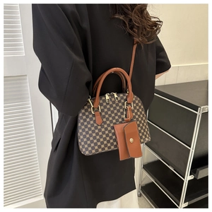 Detail of retro shell handbag with classic geometric pattern and brown leather straps