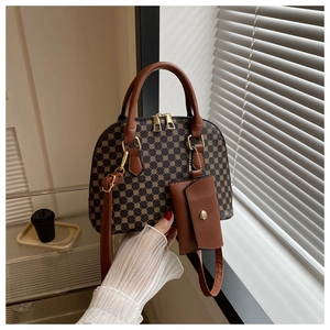 Detail of vintage brown shell bag with geometric pattern, top handle and coin purse