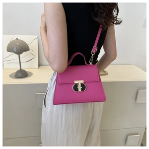 Vista posteriore di una borsa a tracolla magenta con chiusura a T dorata su una modella