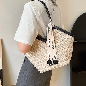 Retro straw tote bag with black leather trim and decorative ribbon for summer commuting