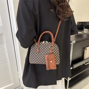 Retro geometric shell handbag with brown leather handles worn by model in suit