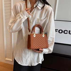 Brown quilted square handbag with a woven handle and crossbody strap for women