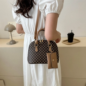 Vintage shell-shaped crossbody handbag with brown pattern and adjustable strap on a model