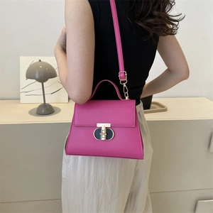 Borsa a tracolla magenta con chiusura dorata e cinturino indossata da modella