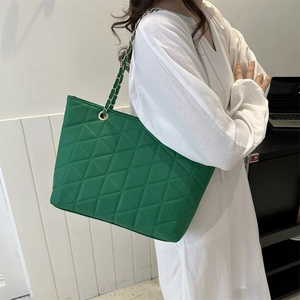 Green quilted tote bag with gold chain strap shown on model for daily casual wear