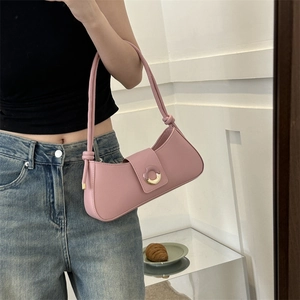 Sac sous le bras minimaliste en cuir rose avec design incurvé et boucle dorée