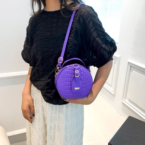 Chic purple crocodile pattern round crossbody bag with gold hardware and shoulder strap