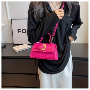 Close-up of hot pink croc-embossed handbag featuring a vintage gold statement buckle