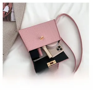Pink croc-embossed square bag showing capacity for phone, lipstick and powder