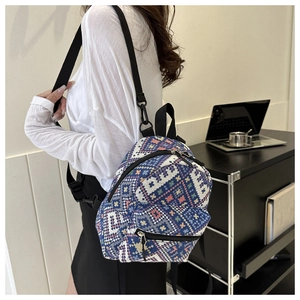 Mini backpack with ethnic geometric patterns on a model showing side back view