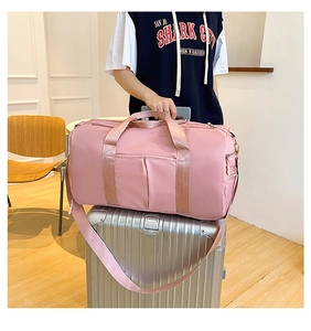 Pink travel bag detail showing the luggage handle sleeve fixed to a silver suitcase