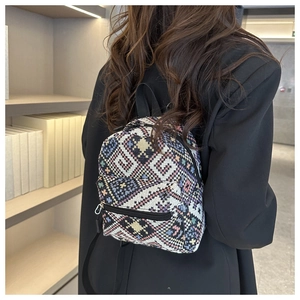 Detail of woven ethnic backpack with geometric patterns and black metal zipper accents
