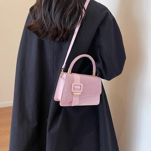Pink patchwork crossbody bag with square buckle worn with a black wool coat