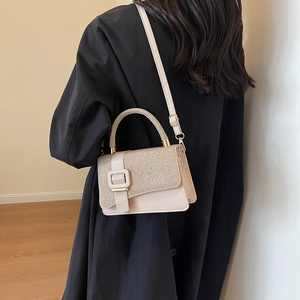 Vintage beige square crossbody bag with glitter flap worn on a black long coat