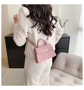 Pink faux crocodile leather bag detail with metallic twist lock and handle back view