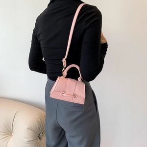 Mini pink hourglass handbag in pebble leather shown as a crossbody on a model