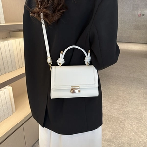 Minimalist white leather crossbody bag with knot handle and gold buckle on model