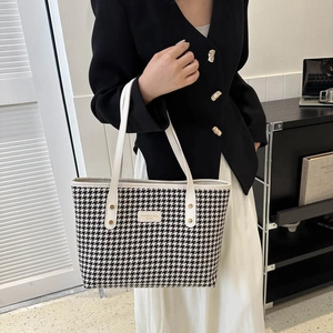 Elegant houndstooth tote bag with black and white texture and white leather handles