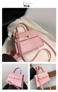 Detail of pink crocodile embossed texture and gold metal turn-lock on the leather bag