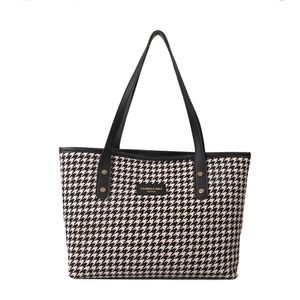 Stylish houndstooth tote bag with black leather straps and classic patterns