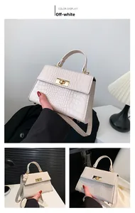 Detail view of cream faux-crocodile leather handbag with gold rotating metal lock