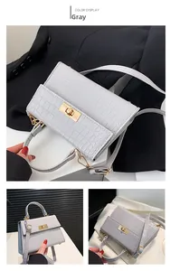 Detail of grey crocodile embossed texture and golden twist lock on stylish handbag