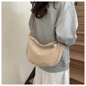 Dettaglio della trama della borsa tote in velluto beige con ciondolo a nuvola e zip
