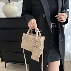 Beige quilted crossbody square bag with mini pouch shown on shoulder with black blazer