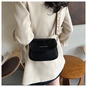 Détail de la sacoche noire en cuir plissé avec bandoulière en jacquard à motifs élégants