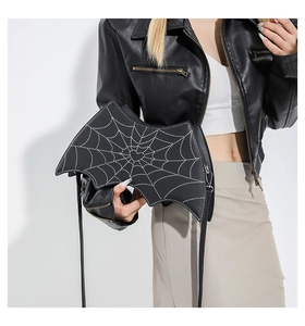 Detailed view of bat-shaped shoulder bag with spider web pattern on model