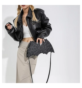 Detail of bat-shaped gothic crossbody bag with spider web and heart embroidery on PU leather