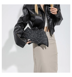 Detail of bat-shaped crossbody bag featuring white spider web pattern and heart detail