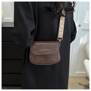 Détail du sac bandoulière vintage marron avec large bandoulière jacquard géométrique