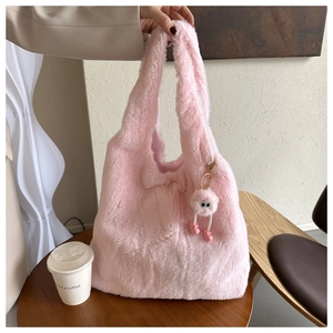 Détail d'un cabas rose en peluche avec pendentif dessin animé et texture duveteuse