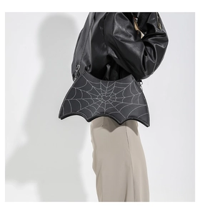 Close-up of black spider web pattern and heart detail on bat-shaped shoulder bag