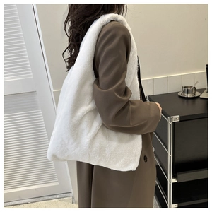 Détail du cabas en fausse fourrure blanche montrant la texture douce et le design porté