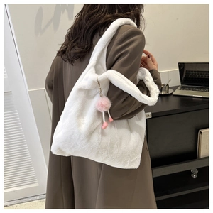 Gros plan d'un cabas en peluche blanche avec un pompon rose pour le trajet quotidien