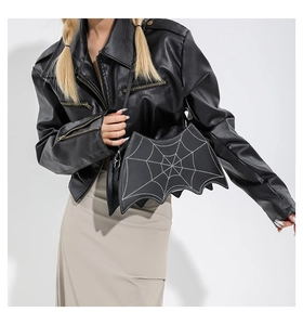 Detailed view of bat-shaped crossbody bag with white spider web pattern on black PU leather