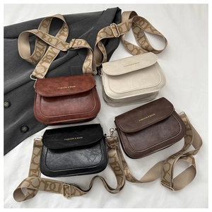 Gros plan de quatre sacs besaces vintage avec larges bandoulières à motifs de plusieurs couleurs