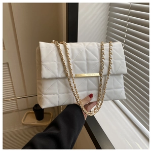 Détail d'un sac à main blanc matelassé avec fermoir doré et bandoulière chaîne