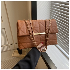Gros plan du sac bandoulière matelassé caramel avec détails dorés et bandoulière chaîne