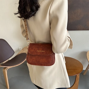 Sac bandoulière vintage marron avec large sangle jacquard sur un blazer beige