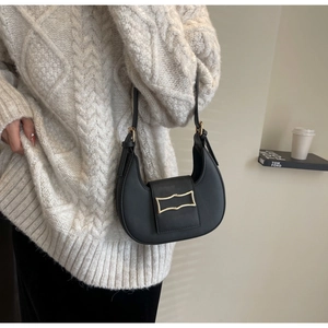 Détail d'un sac à bandoulière demi-lune noir mat doté d'une boucle en métal doré chic