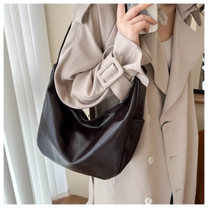 Detail of soft dark brown leather hobo bag with side pocket shown on a model