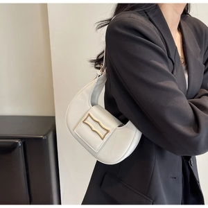 Gros plan sur un sac croissant blanc avec une boucle géométrique en métal doré élégante